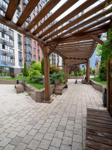 een houten pergola met bankjes in een park bij Seven Hills in Alma-Ata