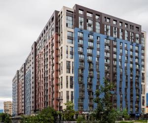 een groot appartementencomplex met een blauwe bij Seven Hills in Alma-Ata +3 foto's
