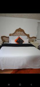 a bed with a white comforter and many pillows at Peace Accommodation B&B in Silver Sands