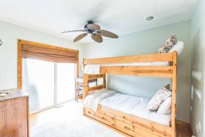 a bedroom with a bunk bed and a ceiling fan at Beach front oasis - Hot tub - Sleeps 7 in Keansburg