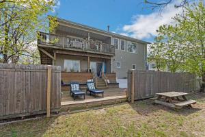a wooden deck with two chairs and a table at Beach front oasis - Hot tub - Sleeps 7 in Keansburg