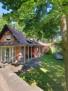 a brick house with a tree in the yard at Upene Home in Iecava