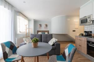 a living room with a couch and a table and chairs at Suites Deluxe By Roque in Vigo
