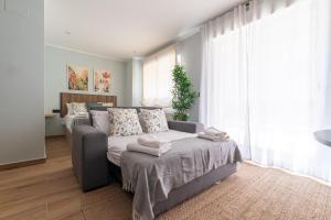 a living room with a bed and a couch at Suites Deluxe By Roque in Vigo