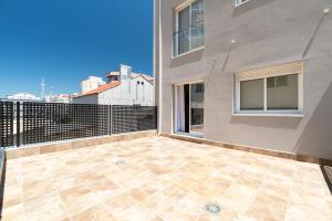 a balcony with a tile floor in front of a building at Suites Deluxe By Roque in Vigo