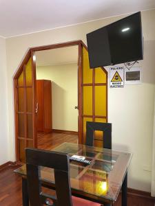a dining room with a glass table and a tv at HOSPEDAJE LAS FLORES ICA in Ica +61 photos
