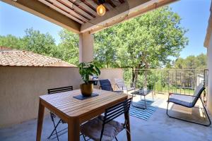 a patio with a wooden table and chairs at The Provencal Escape - Swimming Pool & Nature in Trets