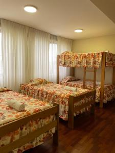 a bedroom with two beds and a bunk bed at HOSPEDAJE LAS FLORES ICA in Ica