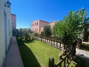 drewniany płot obok podwórza z drzewami w obiekcie Casa vacanza Sardegna viddalba w mieście Villavecchia