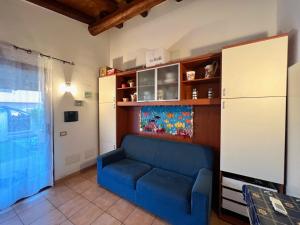 salon z niebieską kanapą i lodówką w obiekcie Casa vacanza Sardegna viddalba w mieście Villavecchia