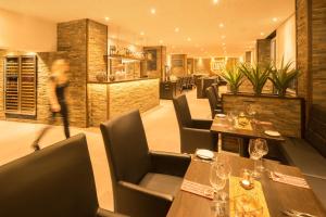 a restaurant with wooden tables and chairs and a bar at Air Hotel Wartburg in Düsseldorf