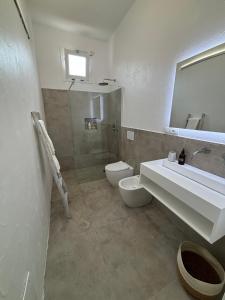 ein Badezimmer mit Waschbecken, Toilette und Spiegel in der Unterkunft Casa Ulivo in Capilungo + 21 Fotos