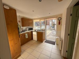 a kitchen with wooden cabinets and a door to a yard at Casa G in Bridlington