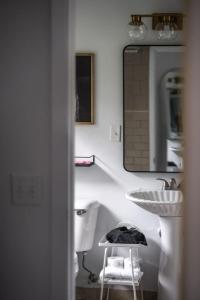 ein Badezimmer mit einem Waschbecken, einem Spiegel und einem Stuhl in der Unterkunft LumberJill Lodge 14 Two Cozy Queen beds in Balsam Lake