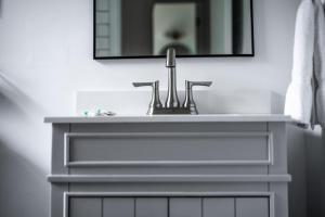 a bathroom with a sink and a mirror at Lumberjill Lodge 13 Double Queen Room in Balsam Lake