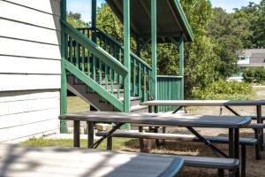 a group of benches sitting outside of a building with a staircase at Lumberjill Lodge 13 Double Queen Room in Balsam Lake +9 photos