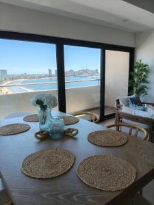 une table avec des assiettes dessus avec vue sur l'océan dans l'établissement Departamento cerca del Malecón, à Mazatlán