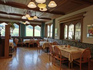 a dining room with tables and chairs and windows at Hotel Sonnblick in Kartitsch