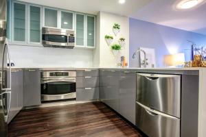 Una cocina con electrodomésticos de acero inoxidable y gabinetes azules. en Luxury 1bedroom 1bath Space Needle, en Seattle 5 fotos más