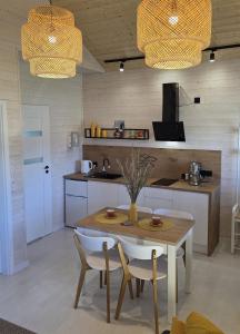 una cucina con tavolo, sedie e lavandino di Domki La Luz a Ustronie Morskie