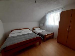 a small bedroom with two beds and a window at Izletište Šabići in Trnovo