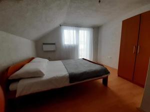 a bedroom with a large bed and a window at Izletište Šabići in Trnovo