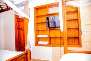 - une chambre avec une télévision dans un meuble en bois dans l'établissement The Keza Hotel and Apartment, à Kigali
