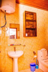 une salle de bain avec un lavabo et des toilettes dans l'établissement The Keza Hotel and Apartment, à Kigali