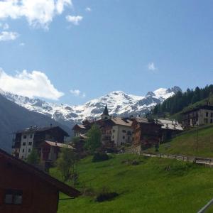 a village with snow capped mountains in the background at Agritur Maso Ciprianna B&B in Rabbi