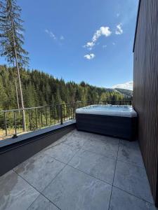 a balcony with a hot tub and a view of the mountains at GirSki in Bukovel