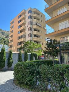 a building with a hedge in front of a building at aldo apartments in Shëngjin