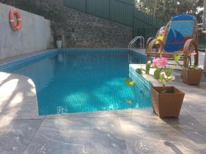 a small swimming pool with a chair and a swing at HELFAROAN Spacious, Superb panoramic view! in Kandy