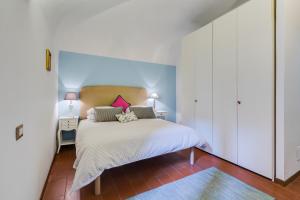 ローマにあるPurificazione 44 Guest Houseのベッドルーム1室(白いシーツとピンクの枕が備わるベッド1台付)