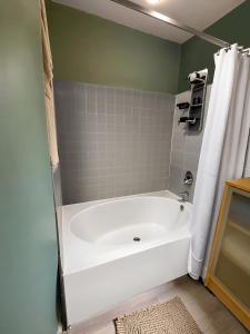 a white bath tub in a bathroom with a shower at Allura Gaslamp Condo - Office Pool Gym & Parking in San Diego
