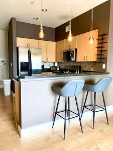 a kitchen with two blue chairs at a counter at Allura Gaslamp Condo - Office Pool Gym & Parking in San Diego +16 photos