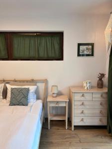 ein Schlafzimmer mit zwei Betten, einer Kommode und einem Fenster in der Unterkunft Pine Tree Residence in Sinaia