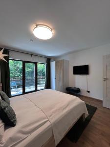 ein Schlafzimmer mit einem großen Bett und einem großen Fenster in der Unterkunft Pine Tree Residence in Sinaia