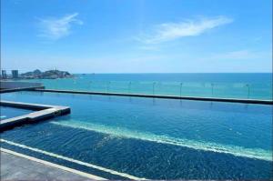 a swimming pool with the ocean in the background at Departamento cerca del Malecón in Mazatlán