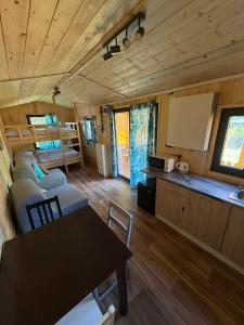 a dining room and kitchen in a tiny house at Sádky Lety in Lety +26 photos