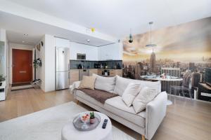 a living room with a couch and a kitchen at Downtown Oulu 2BR, Sauna & Sea View Balcony in Oulu