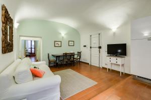 Purificazione 44 Guest House في روما: غرفة معيشة بها أريكة بيضاء وتلفزيون