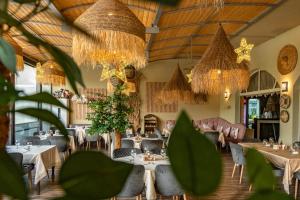 a dining room with tables and chairs and chandeliers at Хотел и Вили Марая apartament in Tsarevo