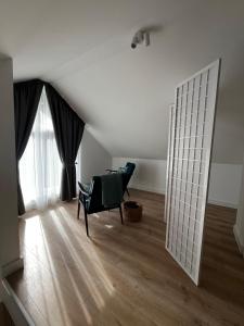 a room with a chair and a large window at Girios Horizontas - Mara in Trakai