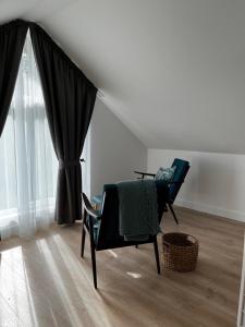 a living room with a chair and a window at Girios Horizontas - Mara in Trakai