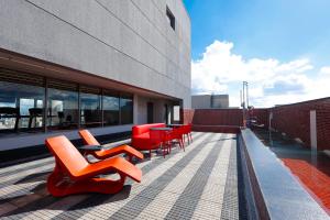 a patio with red chairs and tables on a building at Radisson RED Ibirapuera in São Paulo