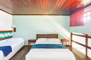 two beds in a room with a wooden ceiling at Flat 208-A Vista Mar com Piscina in Cabo Frio +31 photos