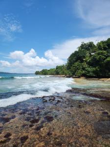a beach with waves crashing on the shore at Tesoro Escondido Ecolodge Cabinas in Bocas del Toro
