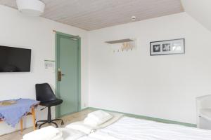 a bedroom with a bed and a chair and a television at Branteviks Bed o Breakfast in Brantevik