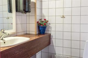 a bathroom with a sink and a vase of flowers on a counter at Branteviks Bed o Breakfast in Brantevik +38 photos