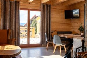 a living room with a table and chairs and a window at Dobry Lot - Agroturystyka in Koniaków